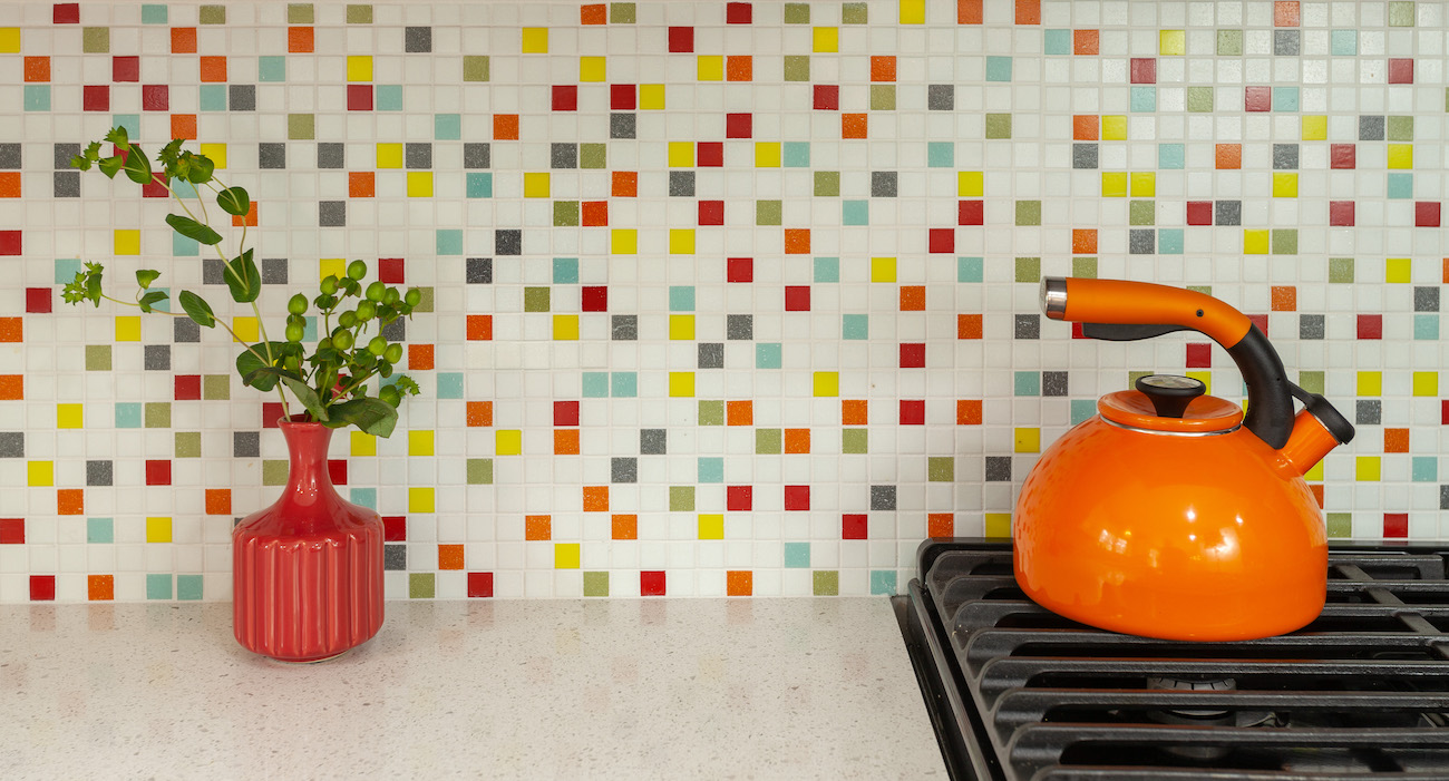 orange-tea-kettle-colorful-tile-backsplash